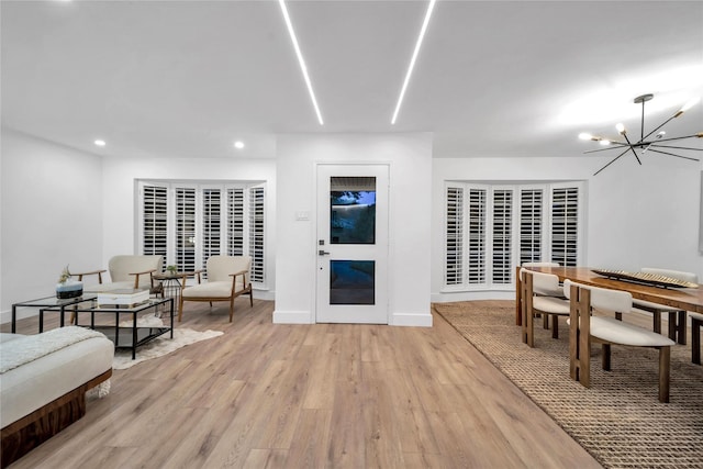 living room with light wood-type flooring and an inviting chandelier