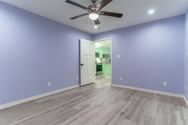 empty room featuring ceiling fan and light hardwood / wood-style flooring