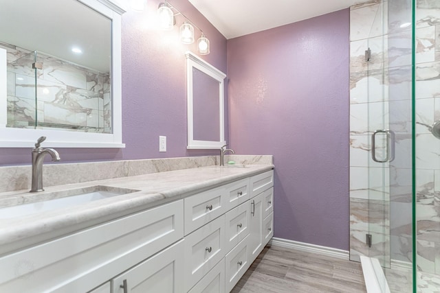 bathroom with vanity, hardwood / wood-style flooring, and a shower with shower door