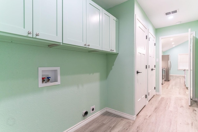 washroom featuring washer hookup, light hardwood / wood-style flooring, cabinets, and hookup for an electric dryer