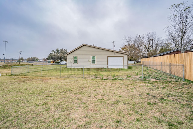 rear view of property with a yard and a garage