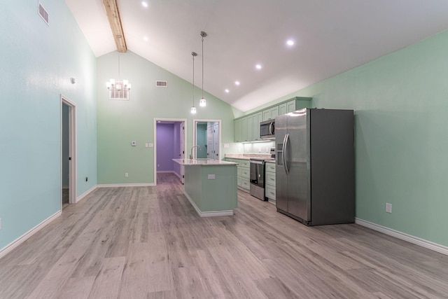 kitchen featuring beam ceiling, stainless steel appliances, pendant lighting, a kitchen island with sink, and light wood-type flooring