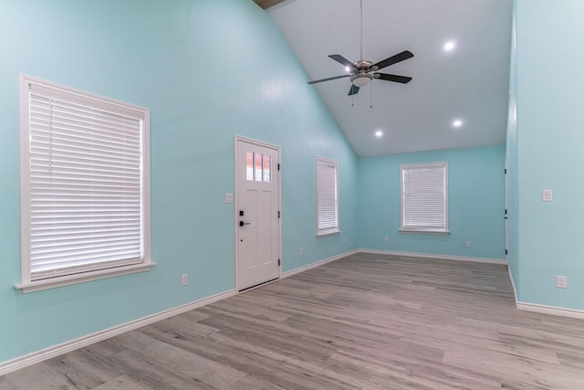 foyer entrance featuring high vaulted ceiling, ceiling fan, and light wood-type flooring