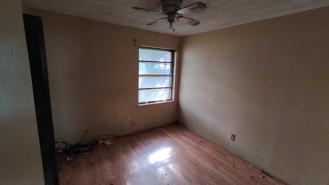 empty room with ceiling fan, a textured ceiling, and light hardwood / wood-style flooring