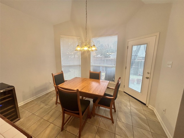 tiled dining area with wine cooler, lofted ceiling, and an inviting chandelier