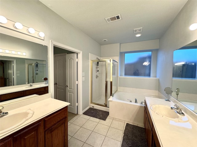 bathroom with tile patterned flooring, vanity, independent shower and bath, and a textured ceiling