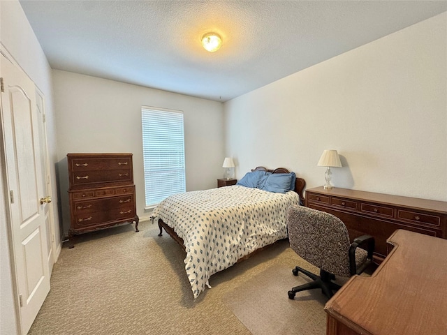 bedroom featuring a textured ceiling and light carpet