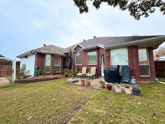 back of property with a lawn and a patio area