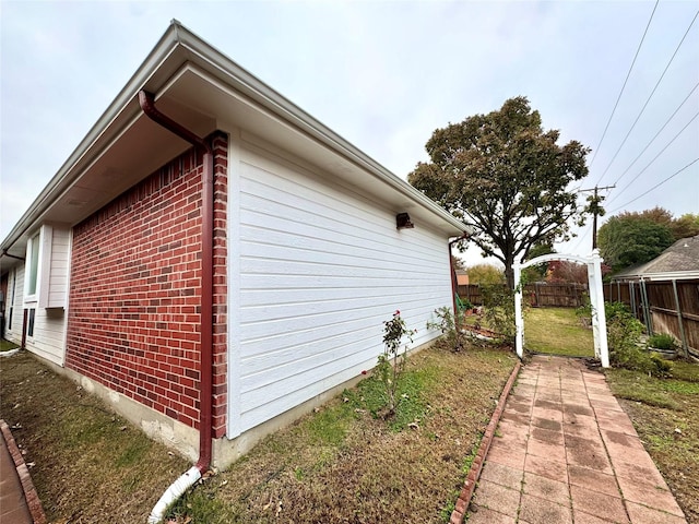 view of side of home with a yard