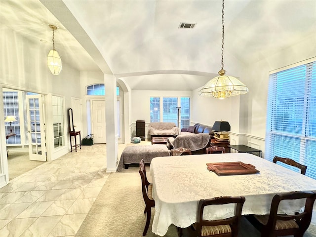 dining space with a chandelier and lofted ceiling