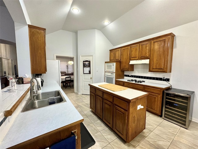 kitchen featuring tile countertops, sink, beverage cooler, and white appliances