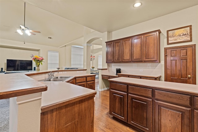 kitchen featuring light wood-type flooring, ceiling fan, lofted ceiling, and sink