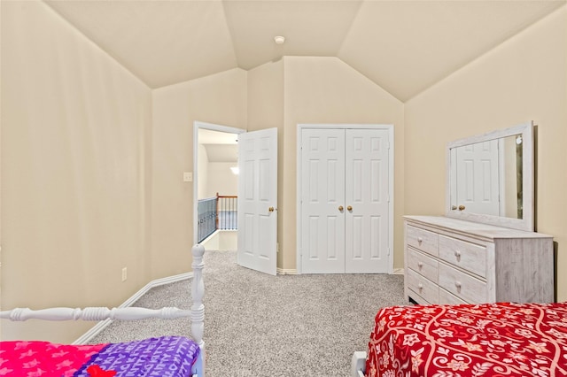 carpeted bedroom with vaulted ceiling and a closet