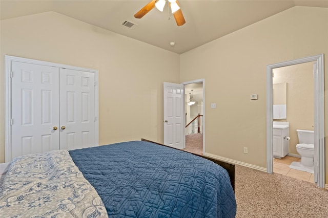 carpeted bedroom featuring ceiling fan, ensuite bath, a closet, and lofted ceiling