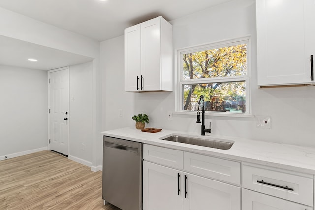 kitchen featuring dishwasher, sink, light stone counters, light hardwood / wood-style floors, and white cabinets