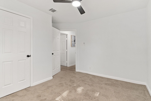 unfurnished bedroom with ceiling fan, a closet, and light colored carpet