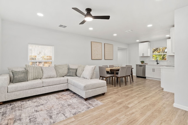 living room with ceiling fan, light wood-type flooring, and sink