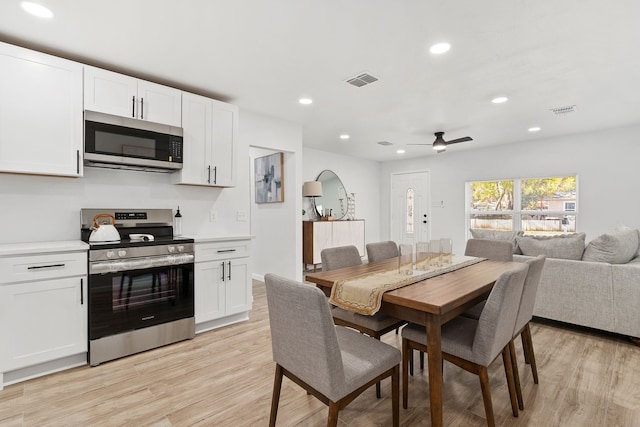 dining area with ceiling fan and light wood-type flooring