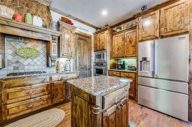 117 Woodland Dr, Krugerville, TX 76227 - kitchen with appliances with stainless steel finishes, backsplash, a center island, crown molding, and light stone countertops