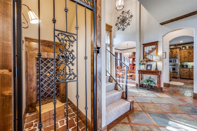 stairs featuring ornamental molding and a high ceiling