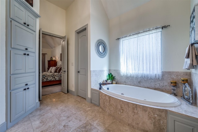 bathroom featuring a relaxing tiled tub and lofted ceiling