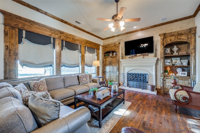 living room featuring dark hardwood / wood-style floors, ceiling fan, built in features, and crown molding