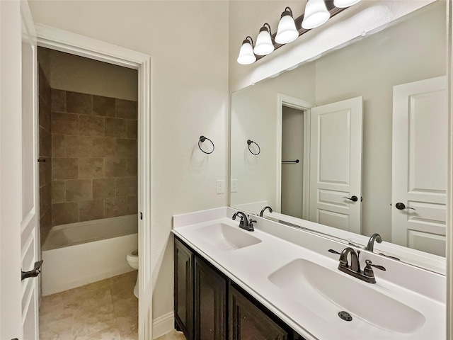 full bathroom with toilet, vanity, and tiled shower / bath