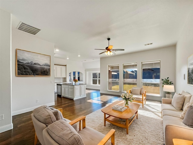 living room featuring ceiling fan, sink, and dark wood-type flooring