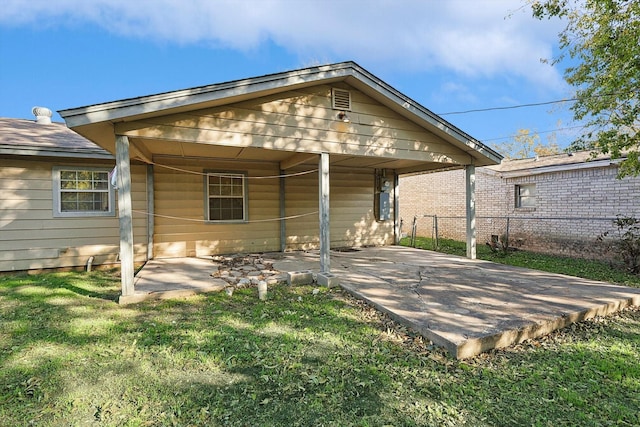 back of property with a lawn and a patio area