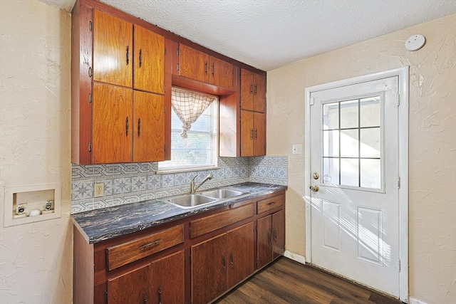 kitchen with a textured ceiling, backsplash, dark hardwood / wood-style floors, and sink