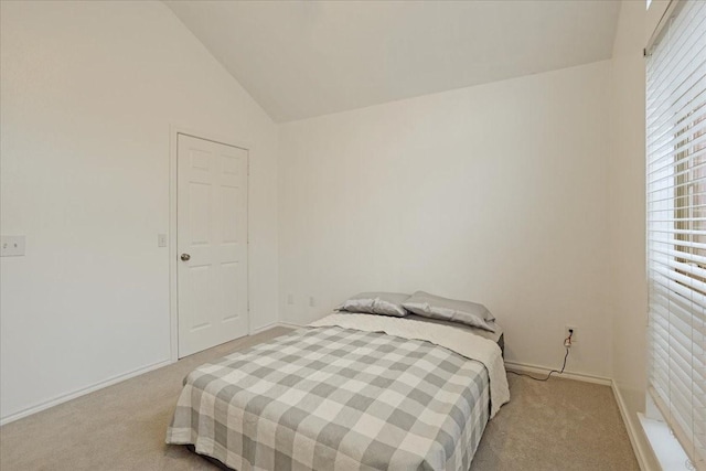 bedroom with light colored carpet and lofted ceiling