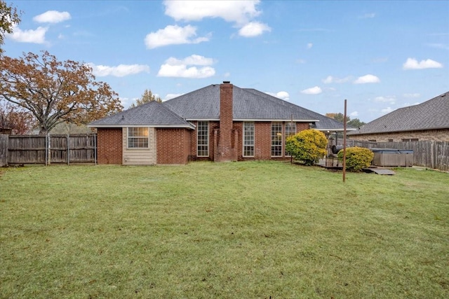 rear view of house with a lawn and a pool