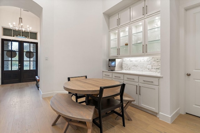 dining area featuring french doors, an inviting chandelier, and light hardwood / wood-style flooring