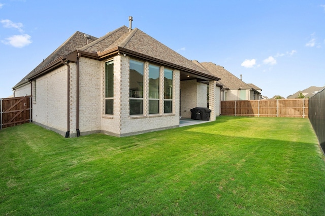 rear view of property featuring a patio and a lawn