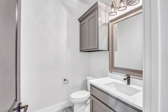 bathroom featuring hardwood / wood-style floors, vanity, and toilet