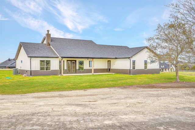 view of front of home featuring a front lawn, central air condition unit, and french doors