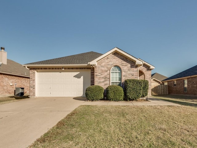 view of front of house with a garage, central air condition unit, and a front yard