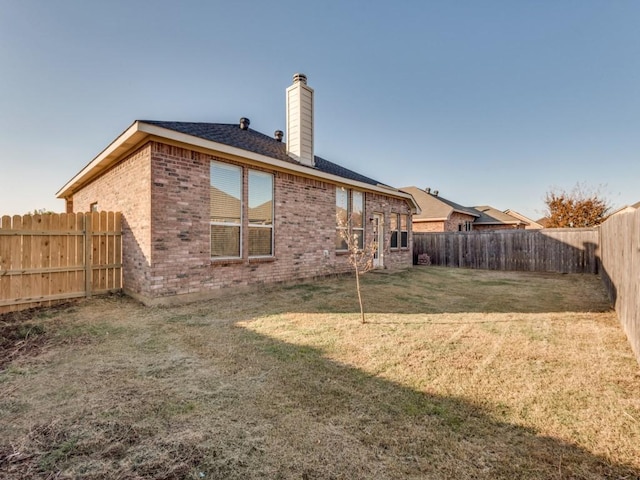 back of house with a lawn