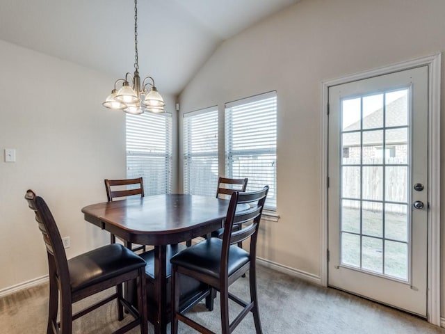 carpeted dining area featuring lofted ceiling and a notable chandelier