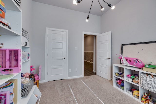 game room with carpet and an inviting chandelier