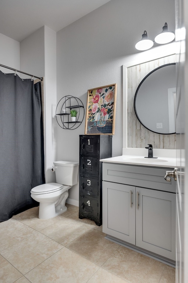 bathroom featuring tile patterned flooring, vanity, and toilet