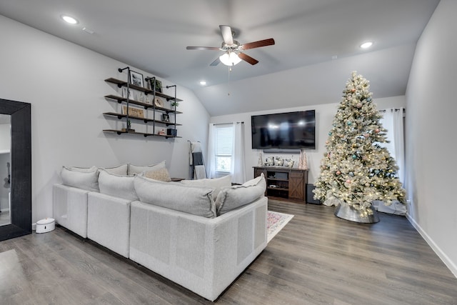 living room featuring ceiling fan, wood-type flooring, and lofted ceiling