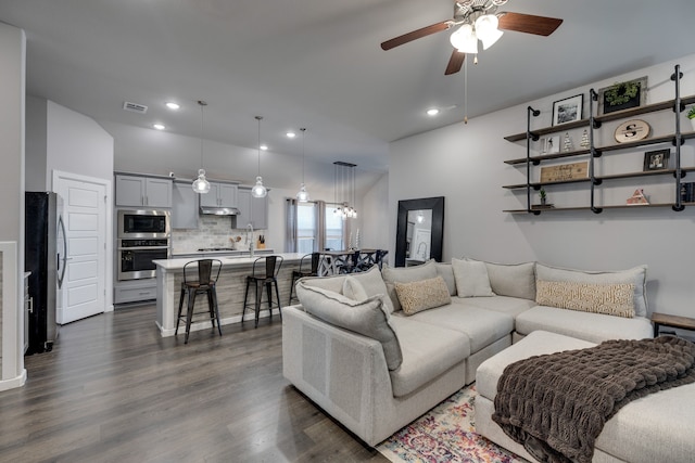 living room with ceiling fan, dark hardwood / wood-style flooring, and sink