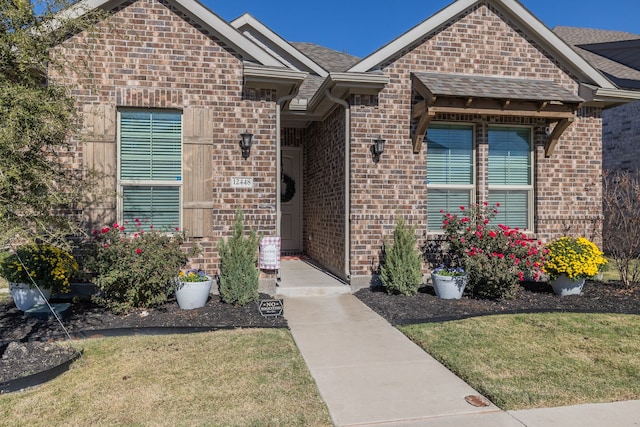 property entrance featuring a lawn