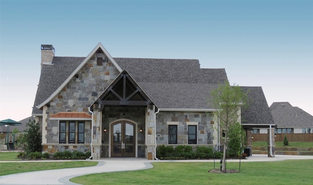 view of front facade with french doors and a front lawn