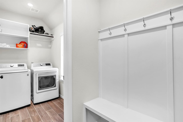 clothes washing area featuring washer and clothes dryer and light hardwood / wood-style flooring