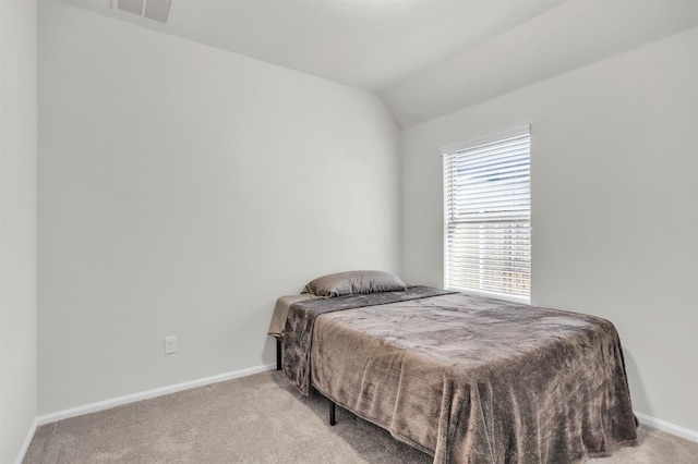 carpeted bedroom with lofted ceiling