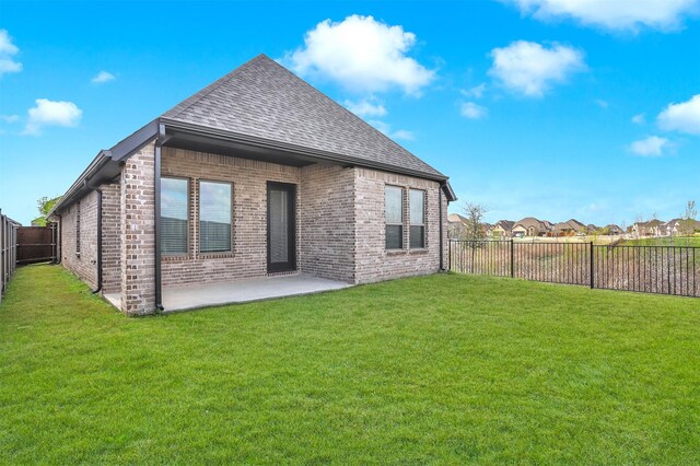 rear view of house featuring a yard and a patio area