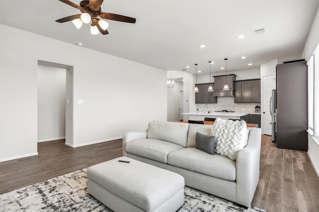 living room with ceiling fan, plenty of natural light, sink, and hardwood / wood-style flooring