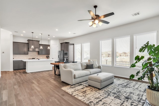 living room featuring ceiling fan and light hardwood / wood-style floors